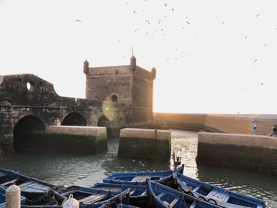 قوارب الصيد وأسوار الساحل مع غروب الشمس.